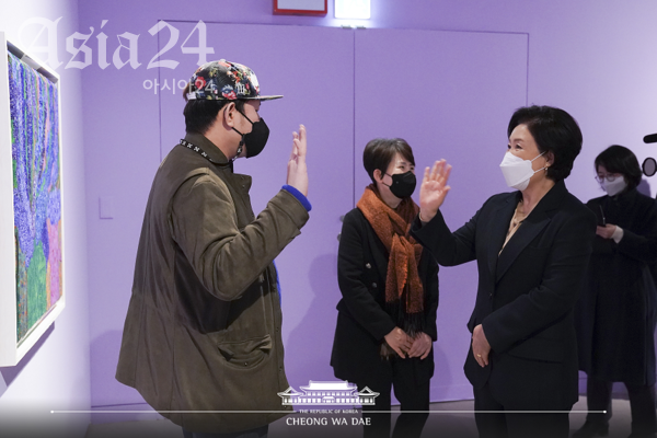 김정숙 여사가 7일 오후 서울 서초구 예술의전당 서예박물관에서 열린 '붓으로 틀을 깨다, 한국 발달장애 아티스트 특별초대전'에서 작가와 인사하고 있다.(청와대 제공) 2022.1.7