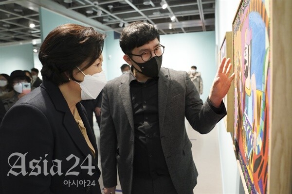 김정숙 여사가 7일 오후 서울 서초구 예술의전당 서예박물관에서 열린 '붓으로 틀을 깨다, 한국 발달장애 아티스트 특별초대전'에서 작가에게 작품 설명을 듣고 있다.(청와대 제공) 2022.1.7